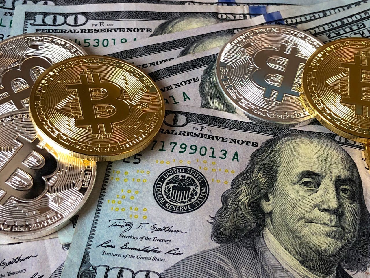 A photo of dollar bills and bitcoins